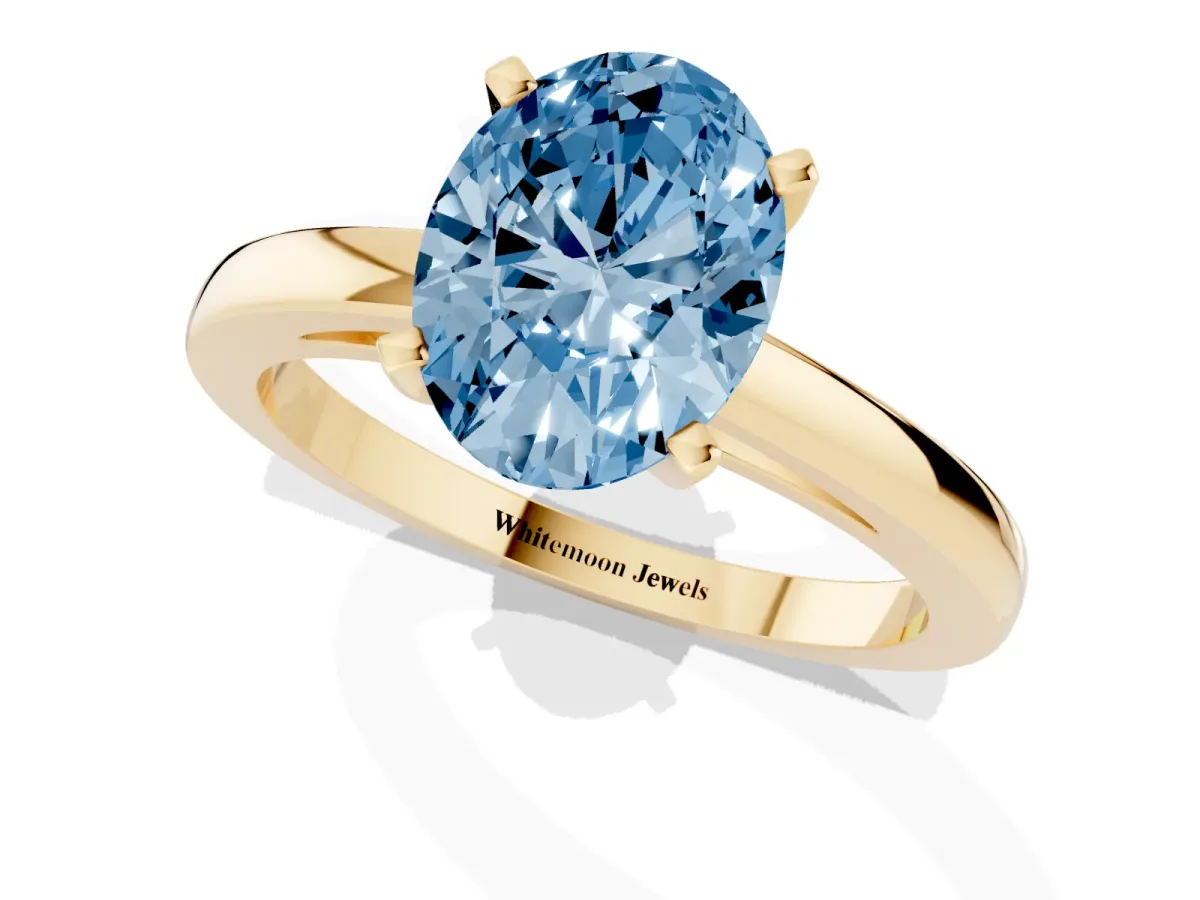 Fancy Blue Oval Cut Solitaire Diamond Engagement Ring with Four-Prong Setting on a Classic Band Yellow gold