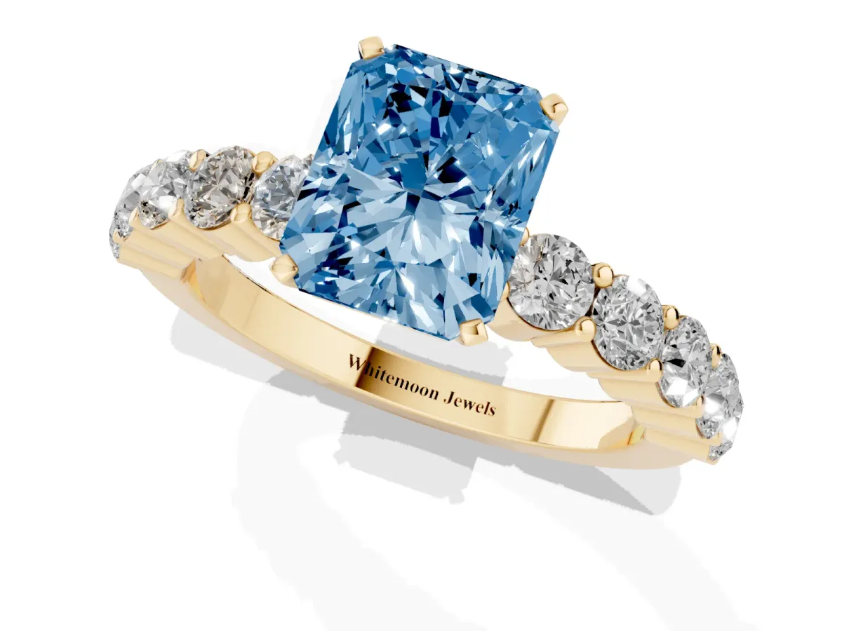 Fancy Blue Radiant Cut Diamond Solitaire Ring with Shared Prong Round Side Stones Yellow gold