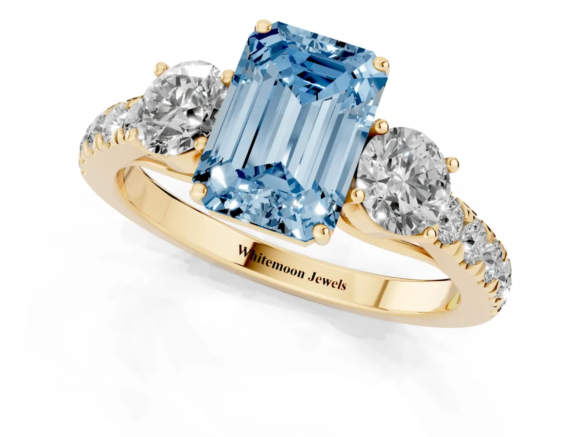 Fancy Blue Emerald Cut Cut Diamond Three-Stone Ring with Round Side Stones and Pavé Band Yellow gold
