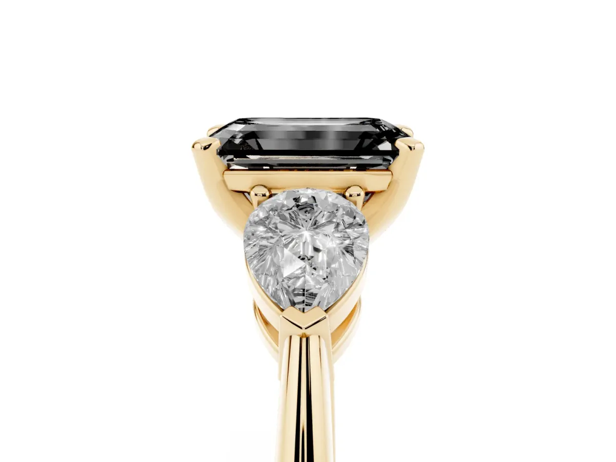 Fancy Black Three-Stone Emerald Cut Diamond Ring with Pear Side Stones and Four-Prong Setting Yellow gold