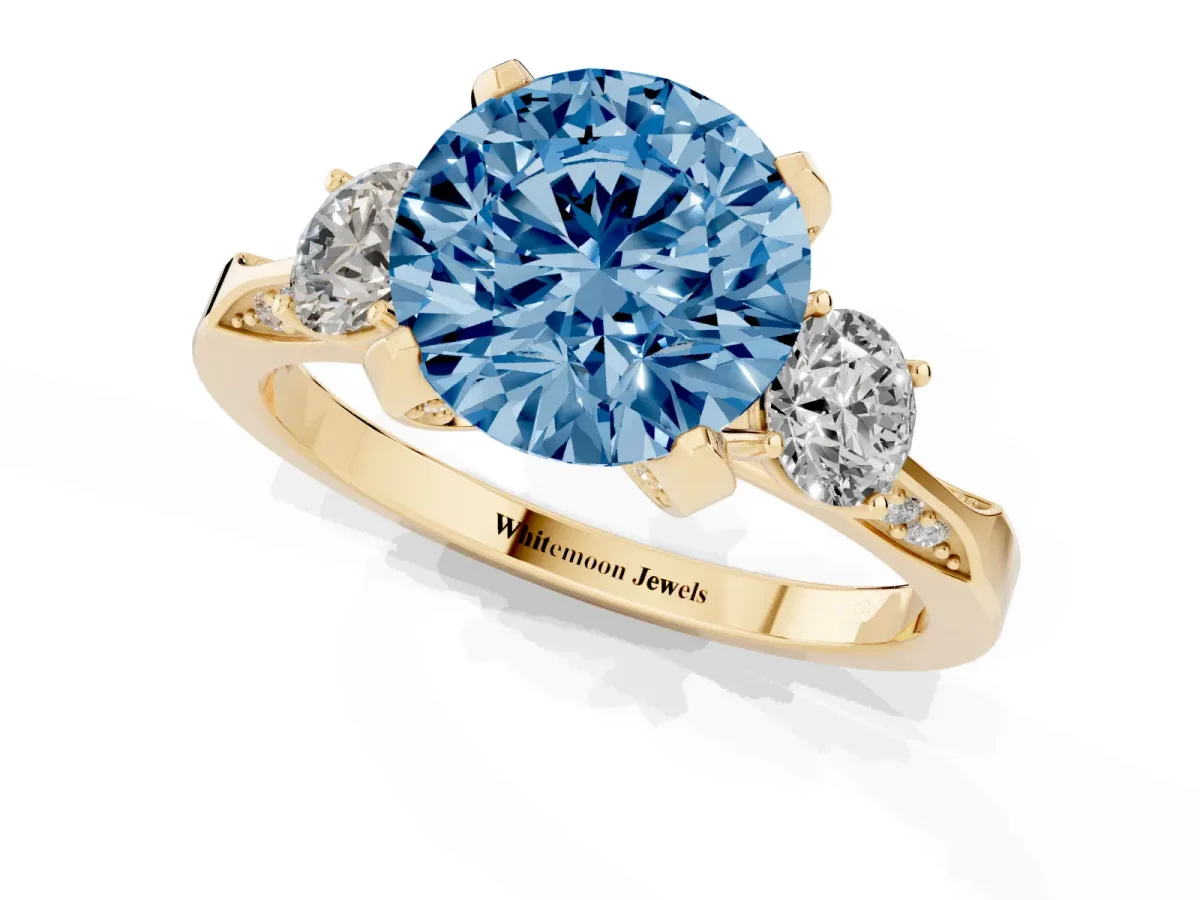 Fancy Blue Round Cut Brilliant Three-Stone Diamond Ring with Pavé Band and Four-Prong Setting Yellow gold