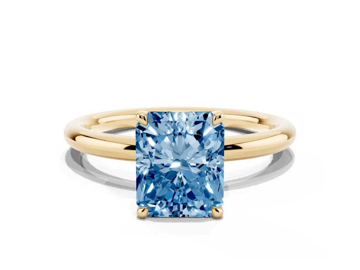 Fancy Blue Radiant Cut Diamond Solitaire Ring with Thin Band and Four-Prong Setting Yellow gold