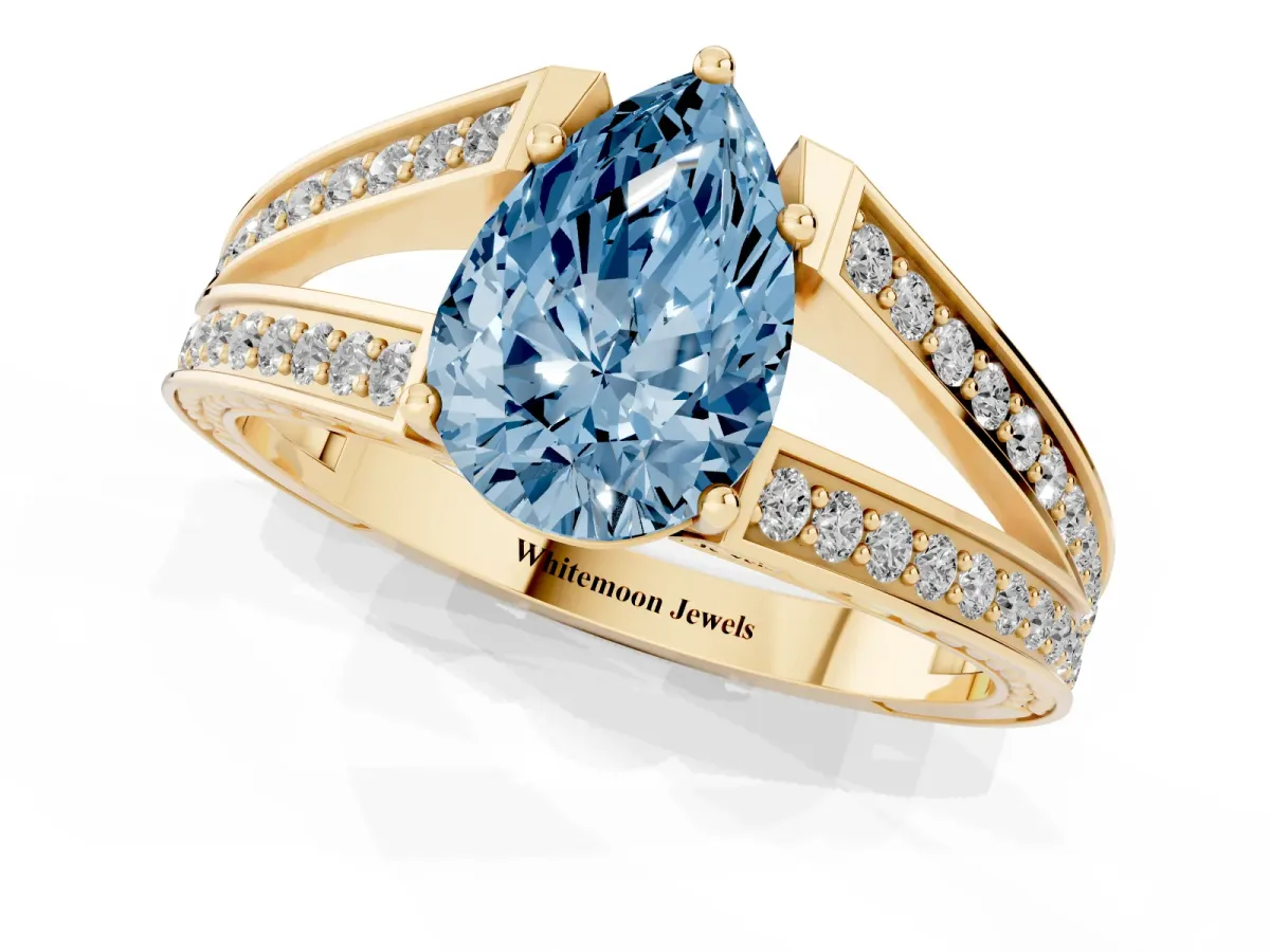 Fancy Blue Pear Cut Diamond Split Shank Ring with Pavé Band and Four-Prong Setting Yellow gold