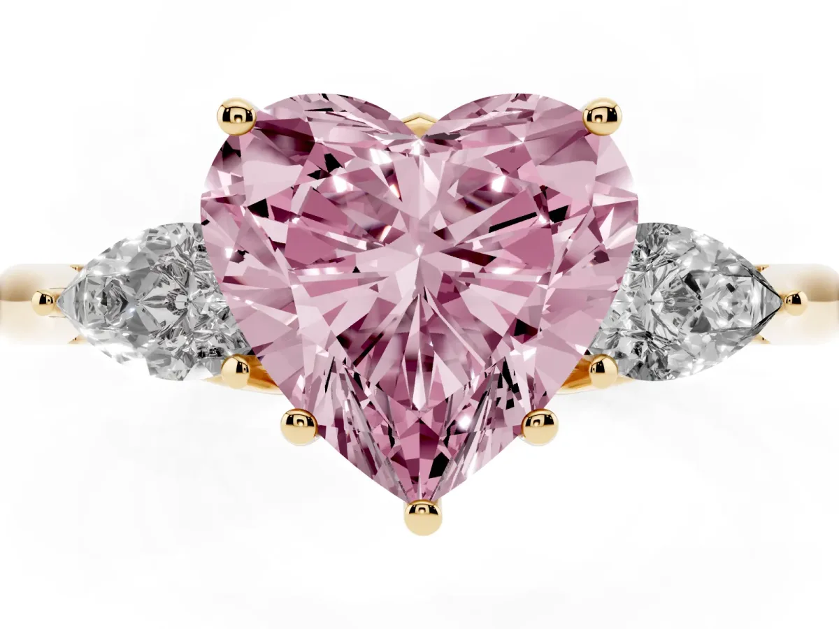 Fancy Pink Three-Stone Heart Cut Brilliant Diamond Solitaire Ring with Tapered Band and Four-Prong Setting Yellow gold