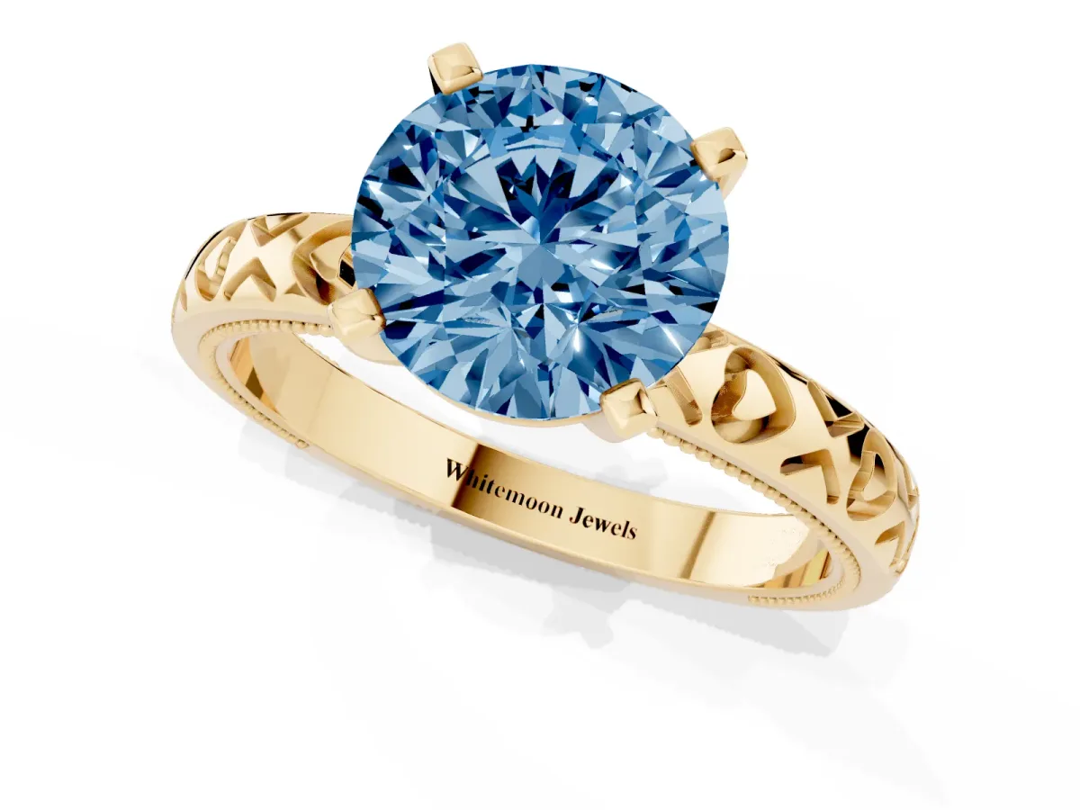 Fancy Blue Round Cut Solitaire Diamond Engagement Ring with XO Engraved Band and Four-Prong Setting Yellow gold