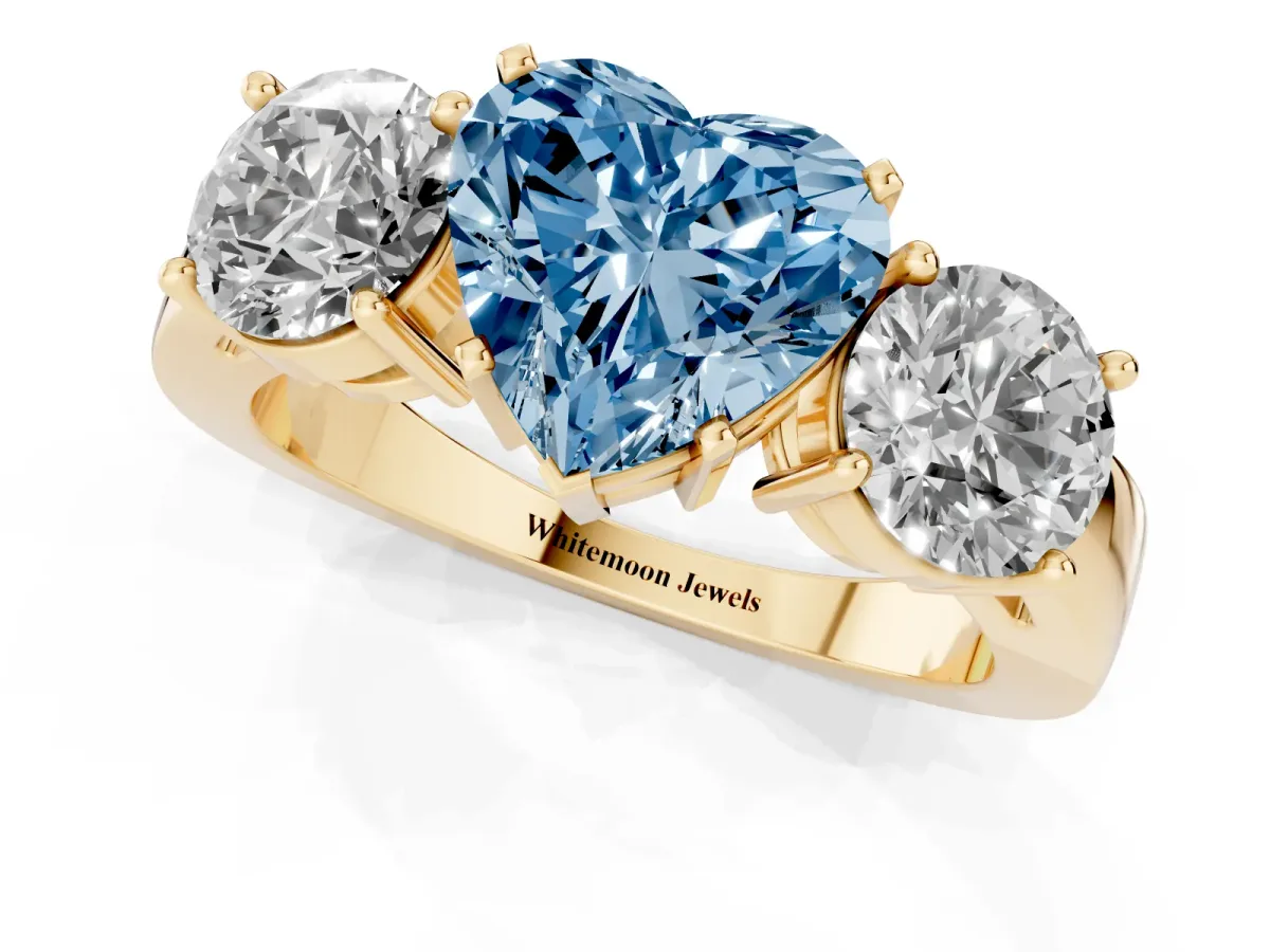 Fancy Blue Three-Stone Heart Cut Diamond Ring with Round Side Stones, Classic Band, and Four-Prong Setting Yellow gold