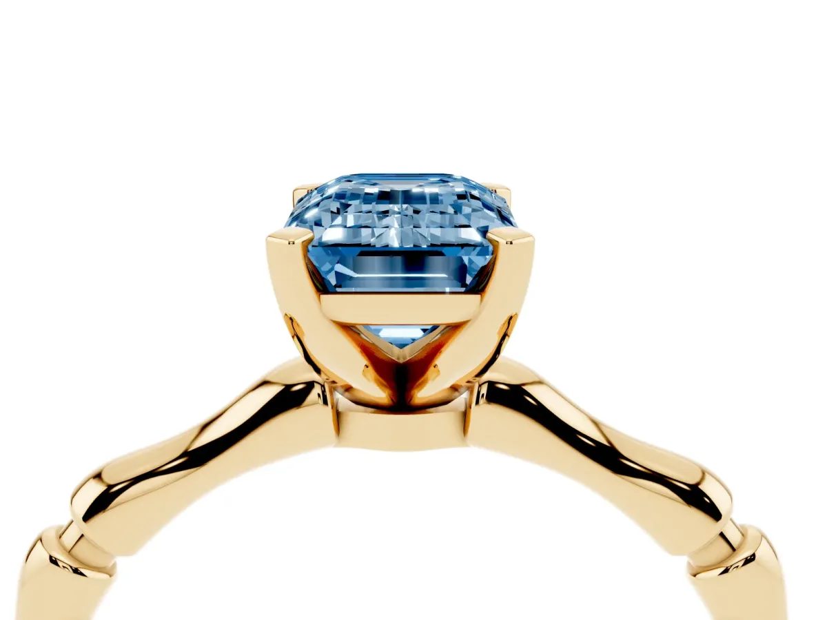 Fancy Blue Emerald Cut Solitaire Diamond Ring with Bamboo Band and Four-Prong Setting Yellow gold