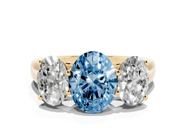 Fancy Blue Oval Cut Three-Stone Diamond Ring with Prong Setting on a Classic Band Yellow gold